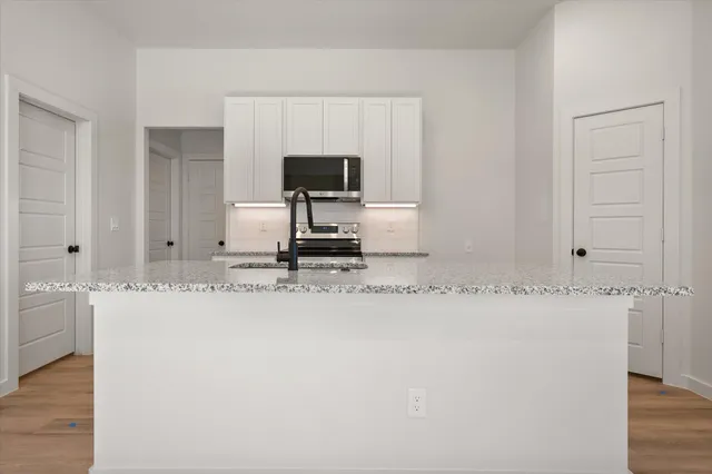 a kitchen with stainless steel appliances granite countertop a sink and a granite counter tops