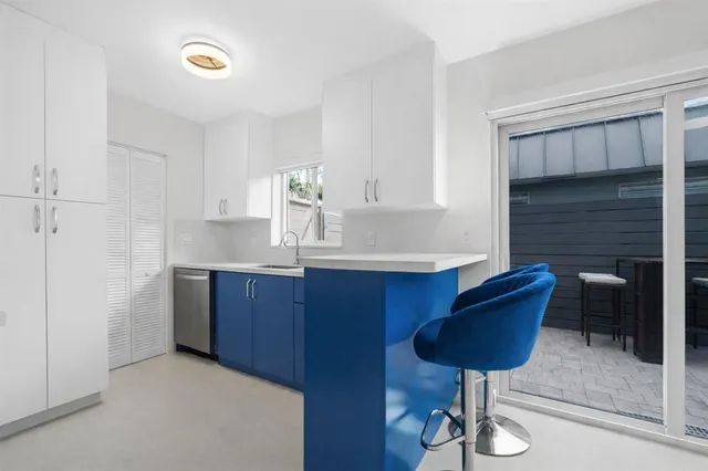 a kitchen with granite countertop a sink cabinets and appliances