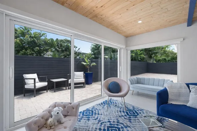 a living room with furniture and a floor to ceiling window