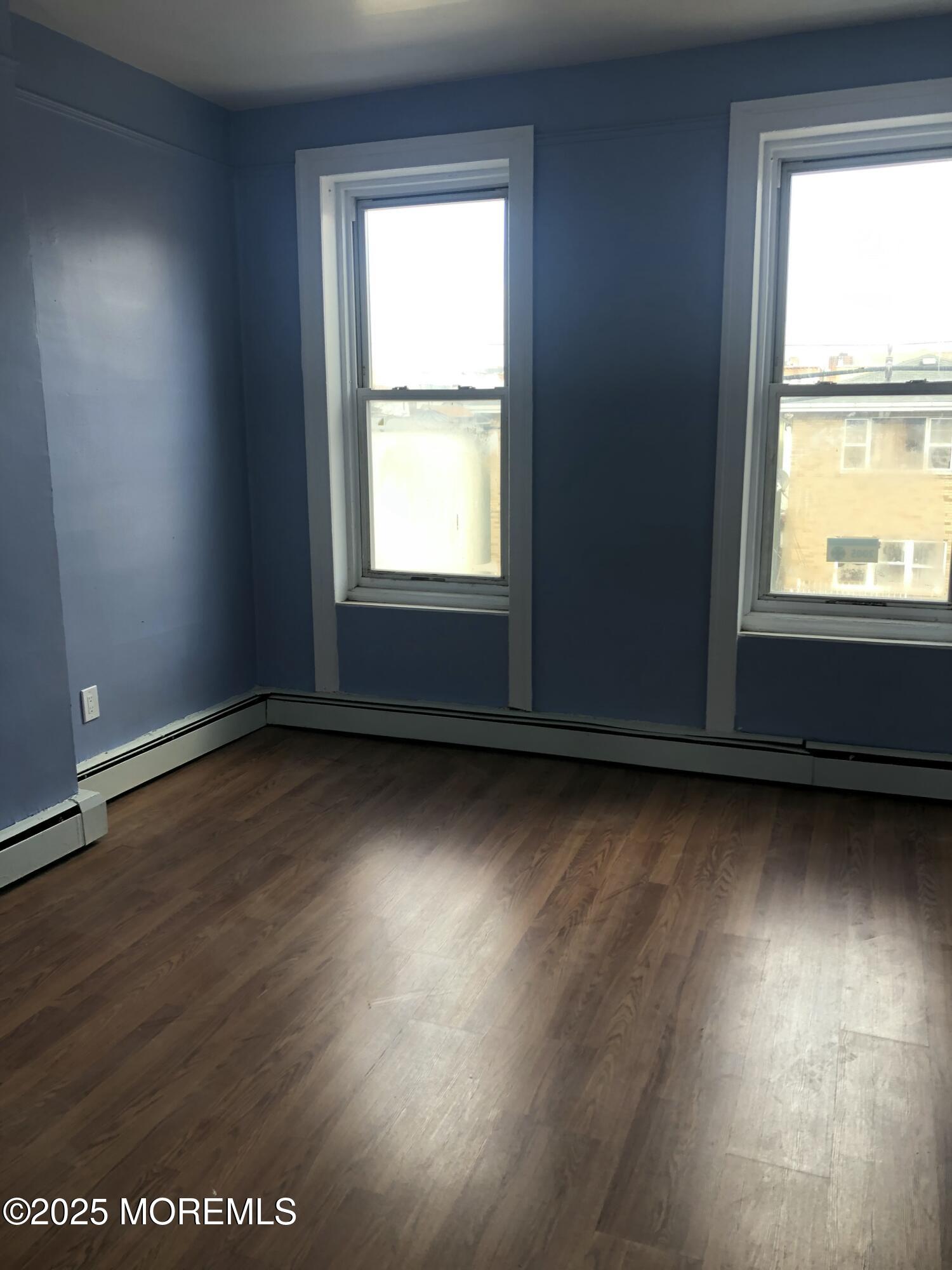 505 5th Street Union City, NJ 07087 - Photo 12 of 16 an empty room with wooden floor and windows
