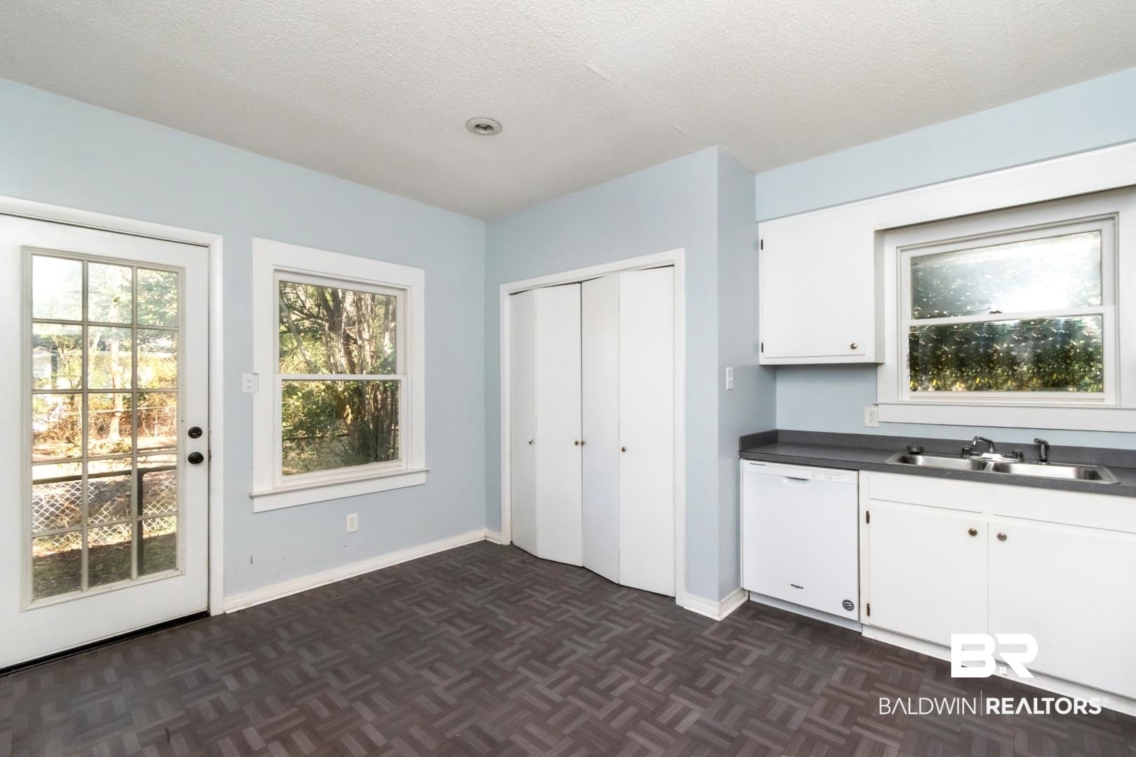 731 Jemison Street Mobile, AL 36606 - Photo 6 of 27 Kitchen with dark countertops, white cabinetry, dishwasher, parquet floors, and a textured ceiling