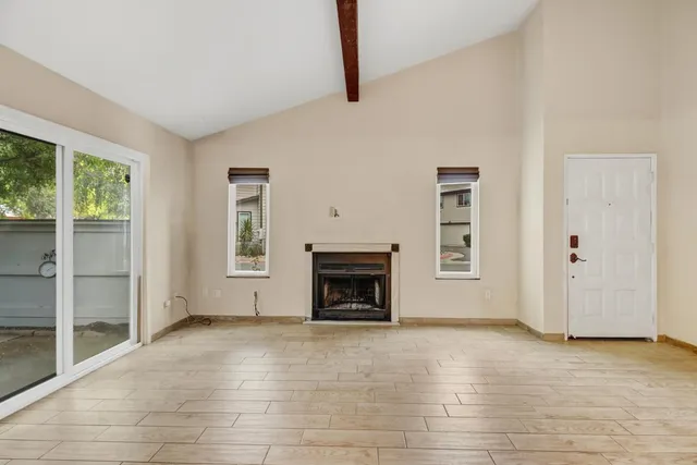 an empty room with windows and fireplace