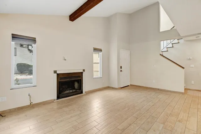 a view of an empty room with a fireplace and a window