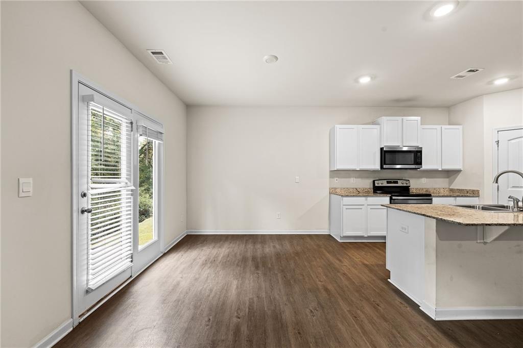 297 Starbuck Parkway Pendergrass, GA 30567 - Photo 23 of 50 a kitchen with wooden floors and black appliances