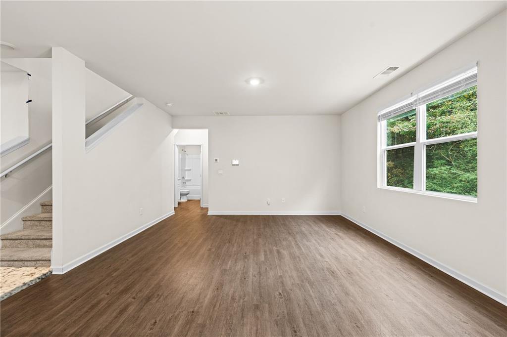 297 Starbuck Parkway Pendergrass, GA 30567 - Photo 24 of 50 a view of an empty room with wooden floor and a window