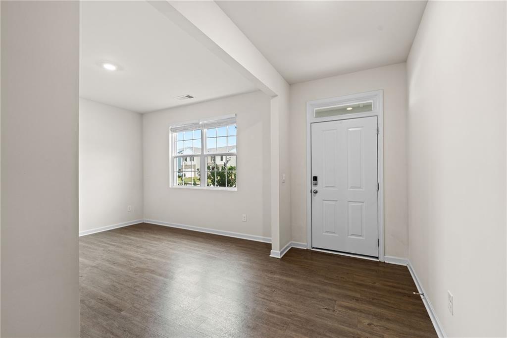 297 Starbuck Parkway Pendergrass, GA 30567 - Photo 4 of 50 an empty room with wooden floor and windows