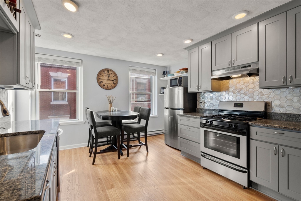 a kitchen with stainless steel appliances granite countertop a stove and a refrigerator