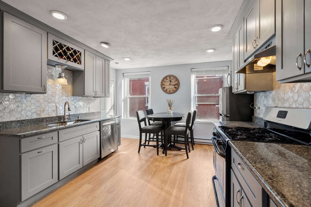 1 Unity Street, Unit 4F Boston, MA 02113 - Photo 3 of 19 a kitchen with stainless steel appliances granite countertop sink stove top oven and cabinets