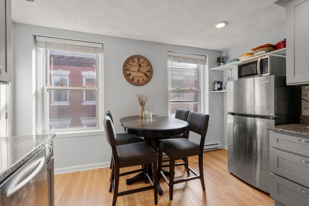 1 Unity Street, Unit 4F Boston, MA 02113 - Photo 8 of 19 a dining room with a table chairs and a refrigerator
