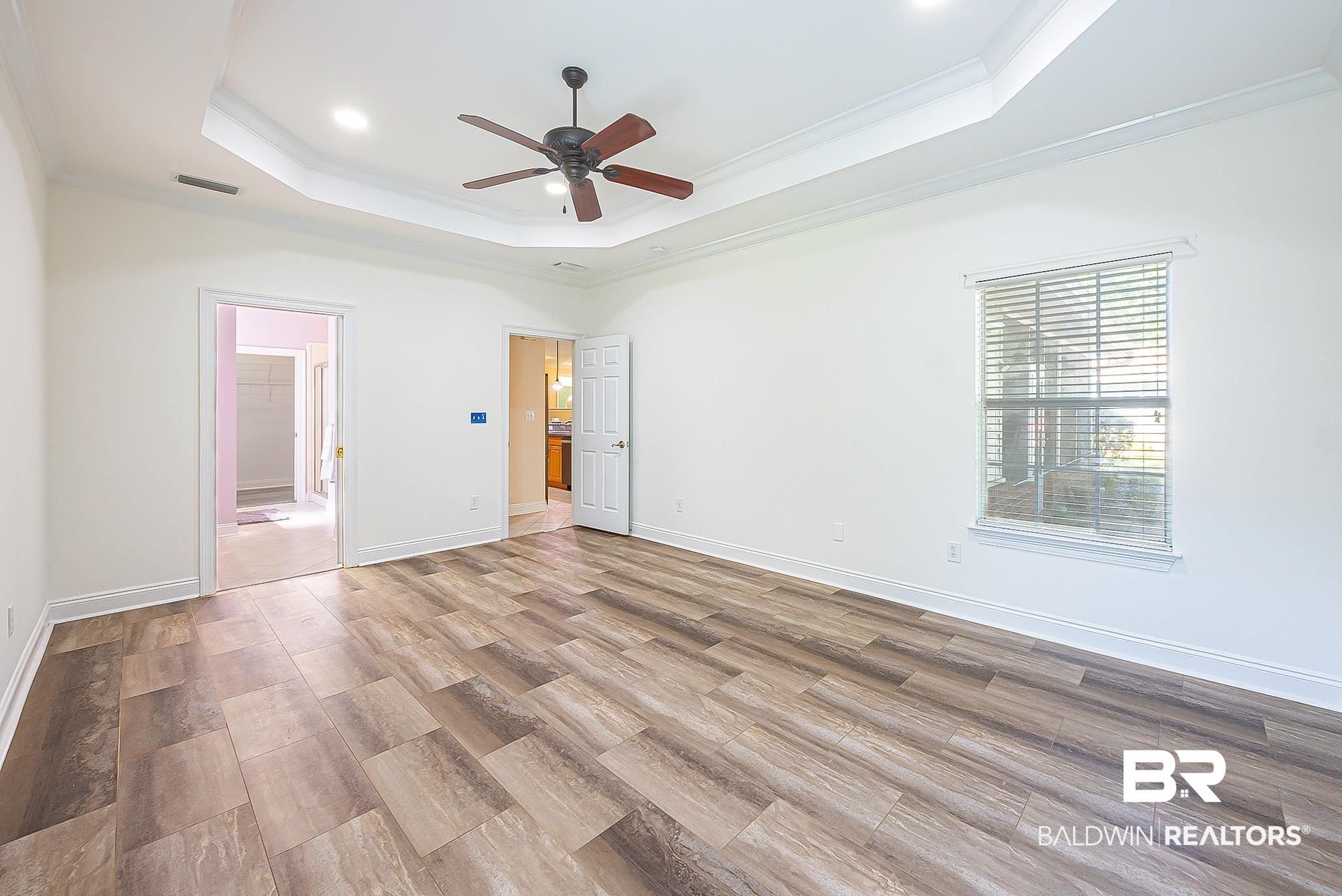 133 Mark Twain Loop Foley, AL 36535 - Photo 31 of 61 Spare room with ceiling fan, ornamental molding, a raised ceiling, and light hardwood / wood-style floors