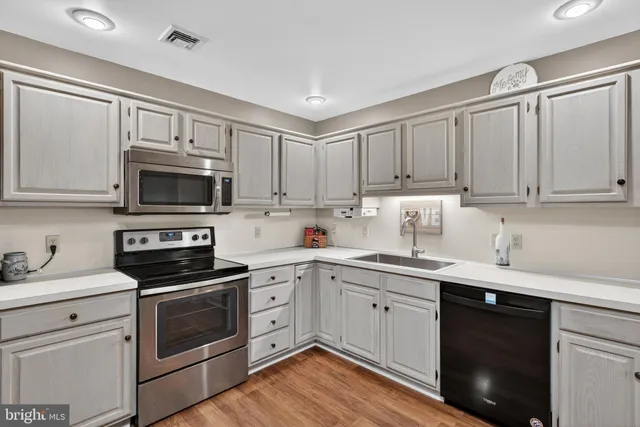 a kitchen with cabinets stainless steel appliances a sink and a microwave