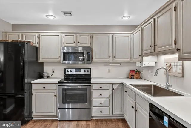 a kitchen with granite countertop a sink stove and refrigerator