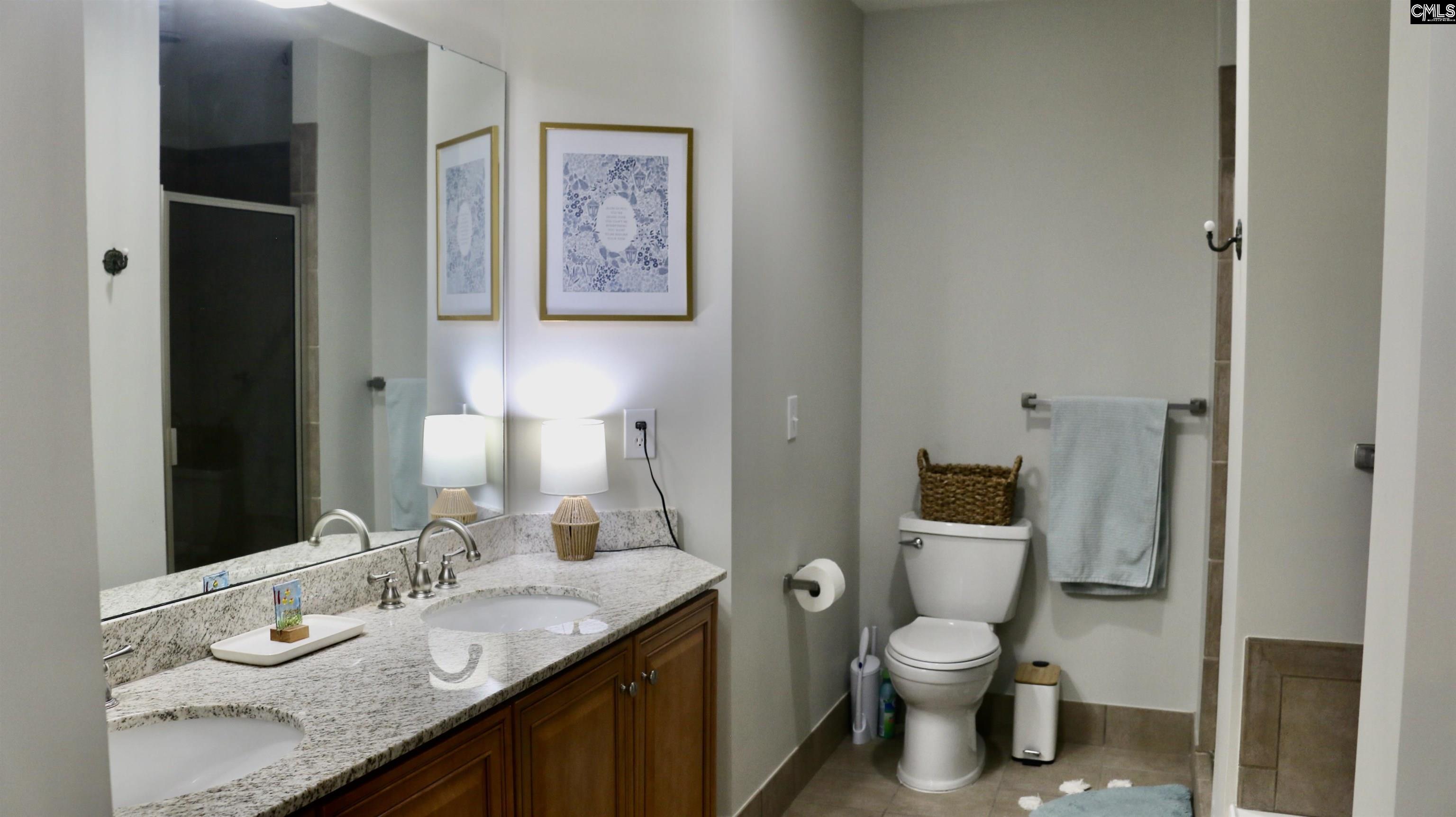 601 Main Street, Unit 323 Columbia, SC 29201 - Photo 33 of 68 a bathroom with a granite countertop toilet sink and mirror