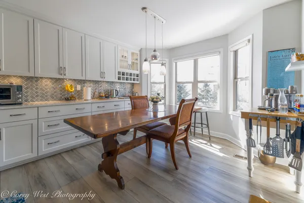 a kitchen with granite countertop a dining table chairs and white cabinets