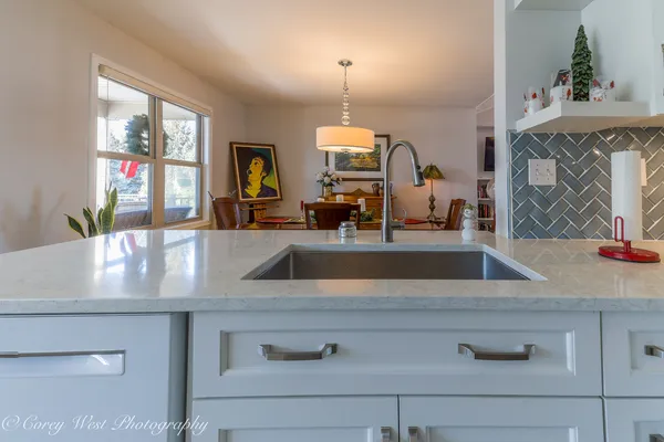 a view with granite countertop a sink and a mirror