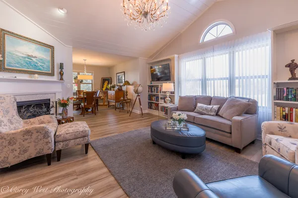 a living room with furniture a fireplace and a large window