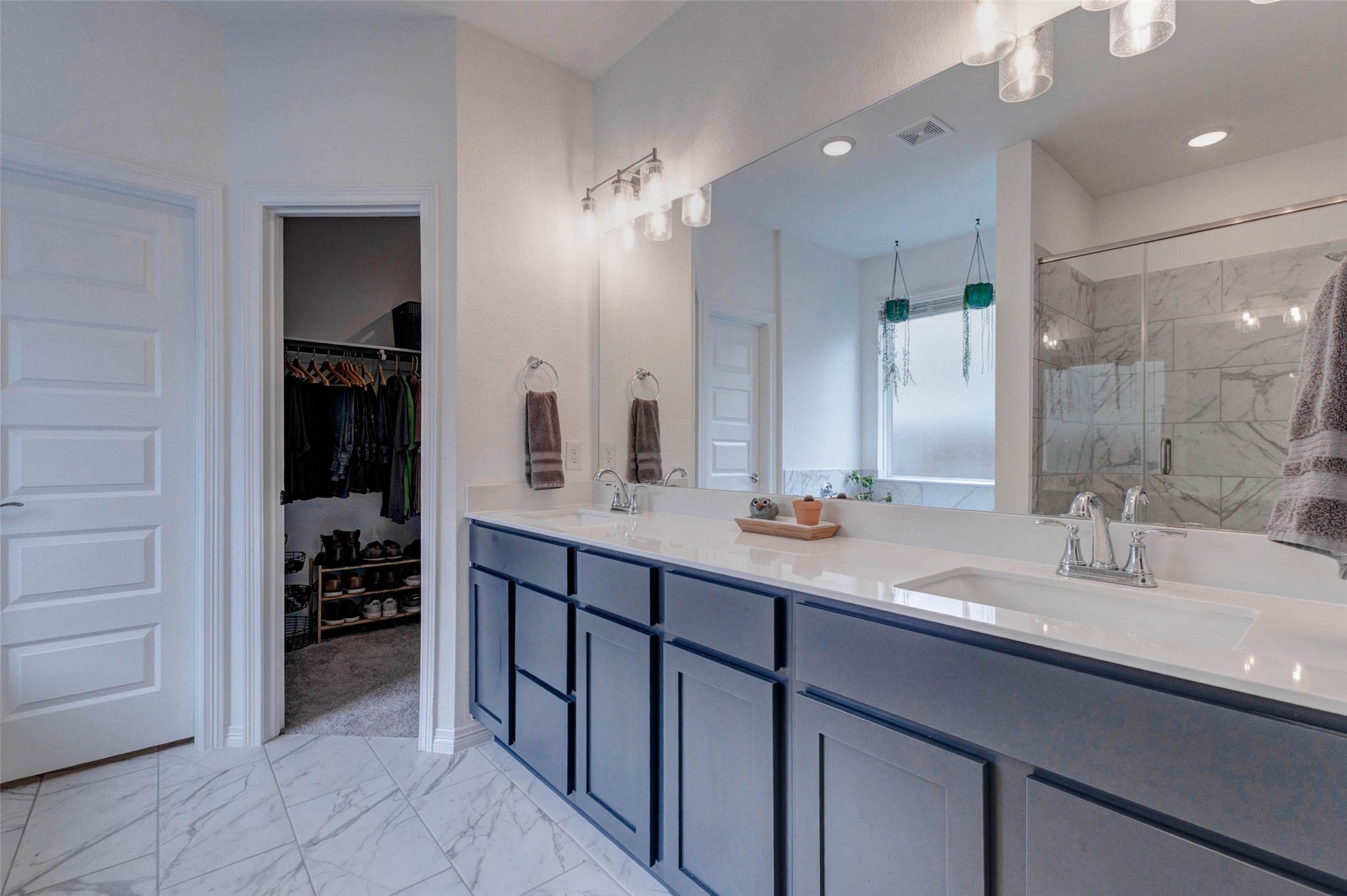 32418 Fly Fish Way Fulshear, TX 77441 - Photo 18 of 40 This closer look at the dual sink vanity showcases the bold blue cabinetry, crisp white countertops, and upgraded light fixtures that give this bathroom its elevated, designer feel.