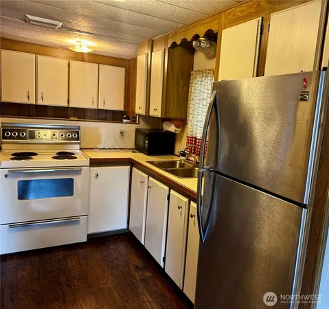 a kitchen with a refrigerator a sink and cabinets