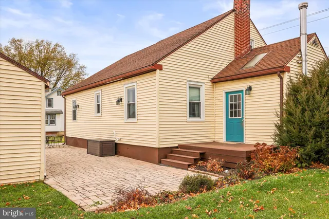 a view of a house with backyard and sitting area