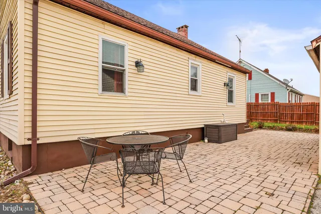 a backyard of a house with wooden chairs