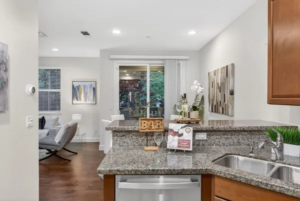 a kitchen with granite countertop a sink and a refrigerator