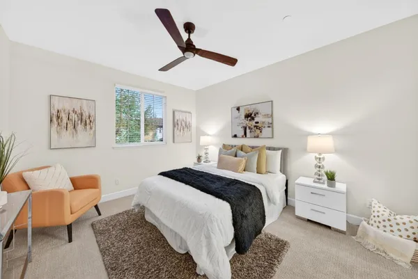 a spacious bedroom with a bed a couch and a window