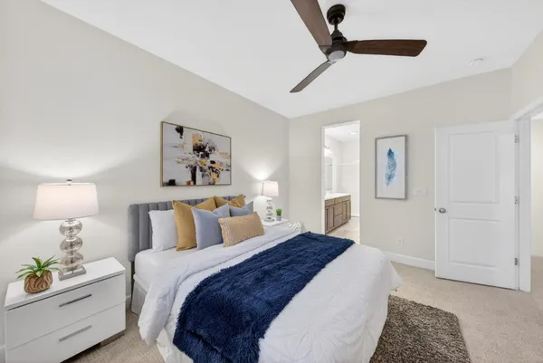 a bedroom with a bed and a lamp on the dresser