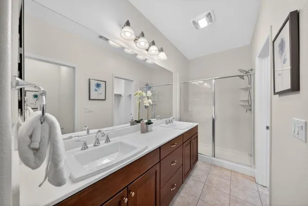 a spacious bathroom with a granite countertop sink a mirror and shower