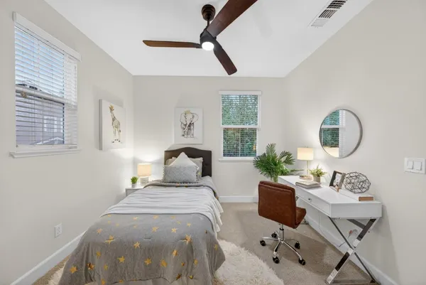 a bedroom with a bed mirror table and window