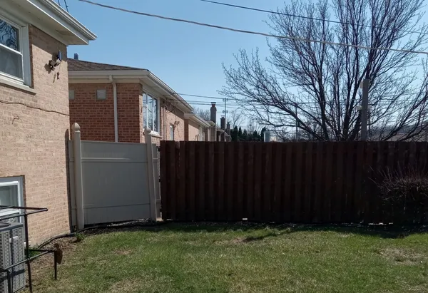 a view of backyard with potted plants and wooden fence