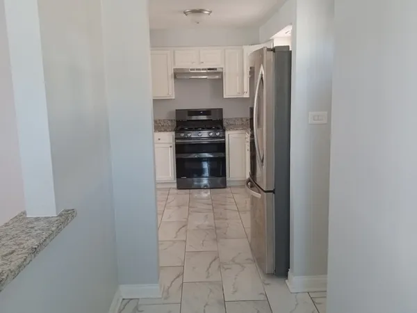 a kitchen with a refrigerator and a stove