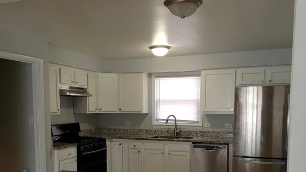 a kitchen with granite countertop stainless steel appliances a refrigerator microwave and sink