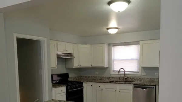 a kitchen with granite countertop a sink cabinets and window