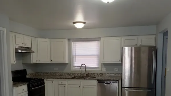 a kitchen with a refrigerator sink and cabinets