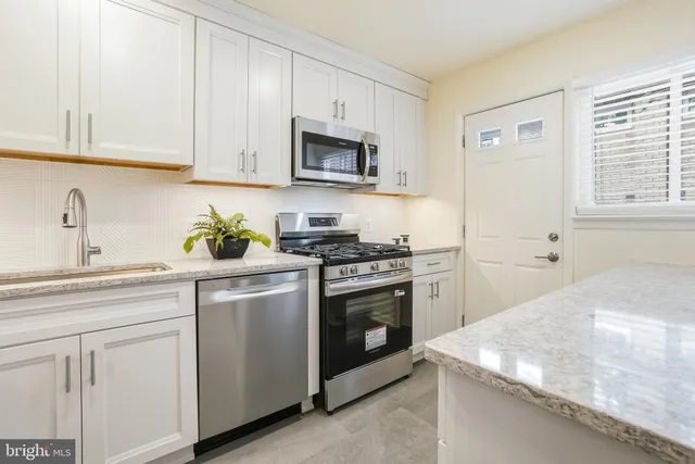 a kitchen with white cabinets and white appliances