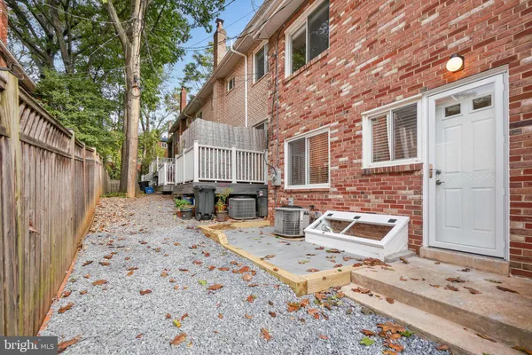 a view of a backyard with table and chairs with wooden fence and plants