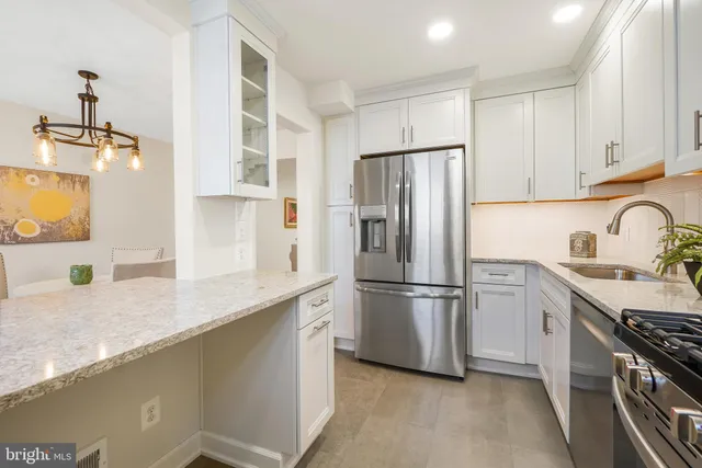 a kitchen with stainless steel appliances granite countertop a refrigerator a sink a stove a microwave and island