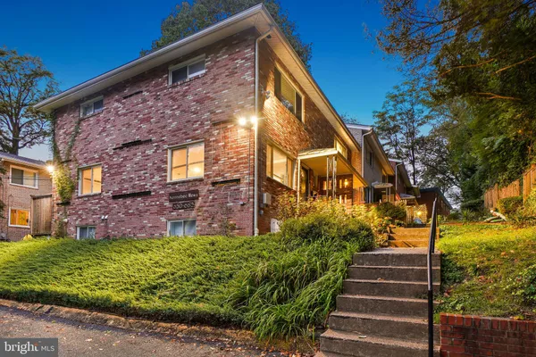 a view of brick house with a yard