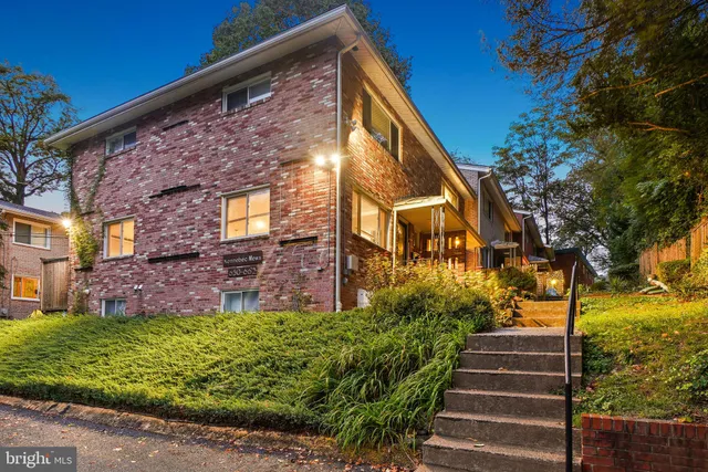 a view of brick house with a yard