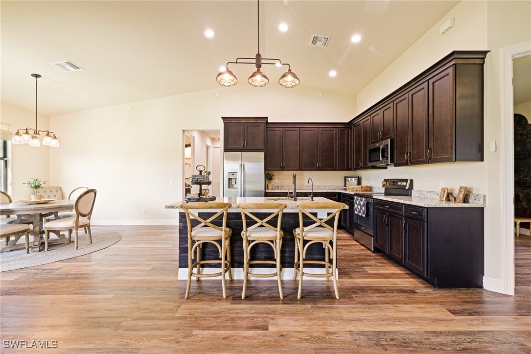 16630 Willow Point Court Alva, FL 33920 - Photo 14 of 46 a view of a dining room with furniture a kitchen and chandelier
