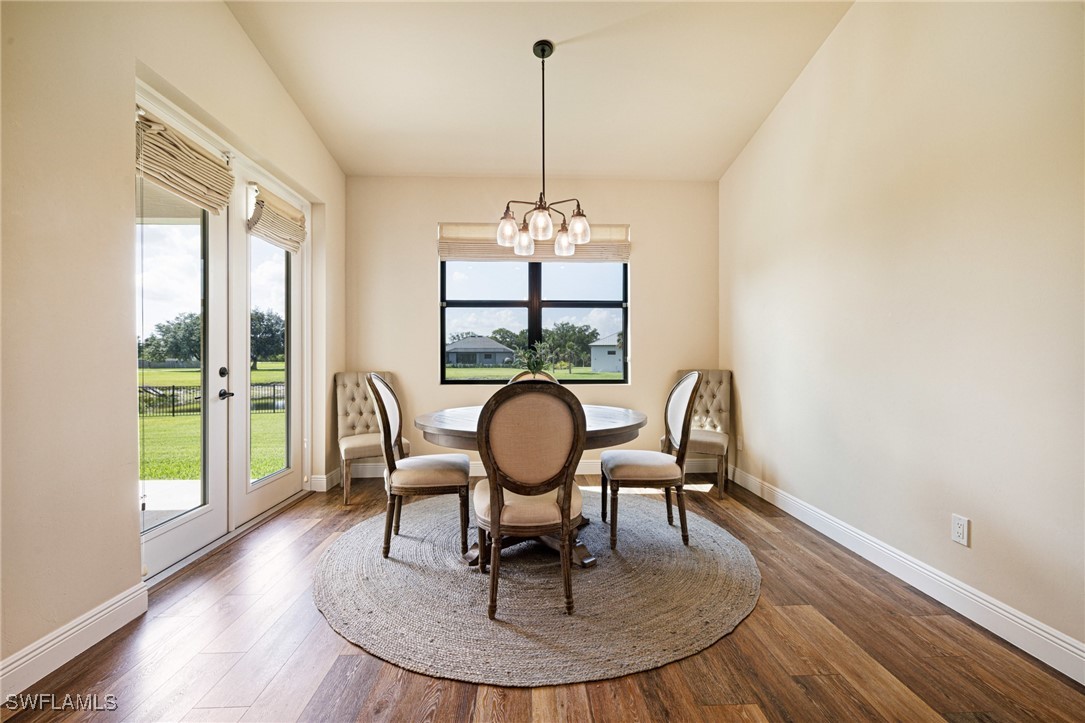 16630 Willow Point Court Alva, FL 33920 - Photo 16 of 46 a dining room with furniture a chandelier and wooden floor