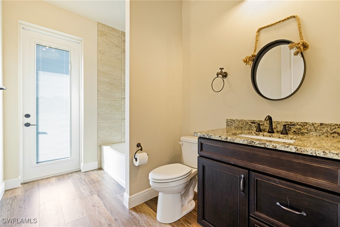 16630 Willow Point Court Alva, FL 33920 - Photo 27 of 46 a bathroom with a granite countertop toilet a sink and a mirror