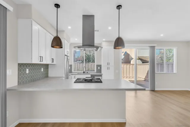 a kitchen with stainless steel appliances granite countertop a sink a window and chairs
