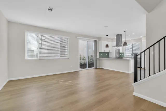 a view of empty room with wooden floor and windows