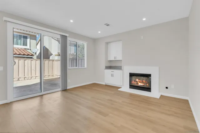 a view of an empty room with window and fire place