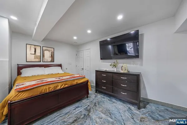 a spacious bedroom with a bed and a flat screen tv
