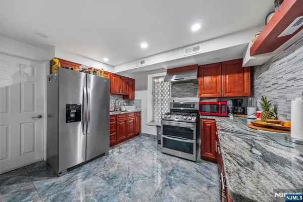 a kitchen with stainless steel appliances granite countertop a refrigerator and a stove