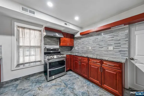 a kitchen with stainless steel appliances granite countertop a stove sink and cabinets