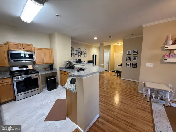 a kitchen with stainless steel appliances kitchen island granite countertop a stove a sink and a refrigerator