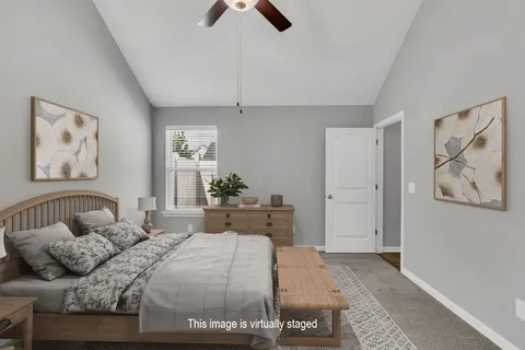 a bedroom with a large bed and a chandelier